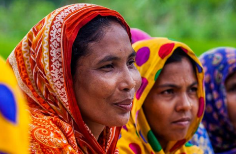 Women seated outside in colorful clothes 