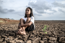 Girl sitting in dried a field 